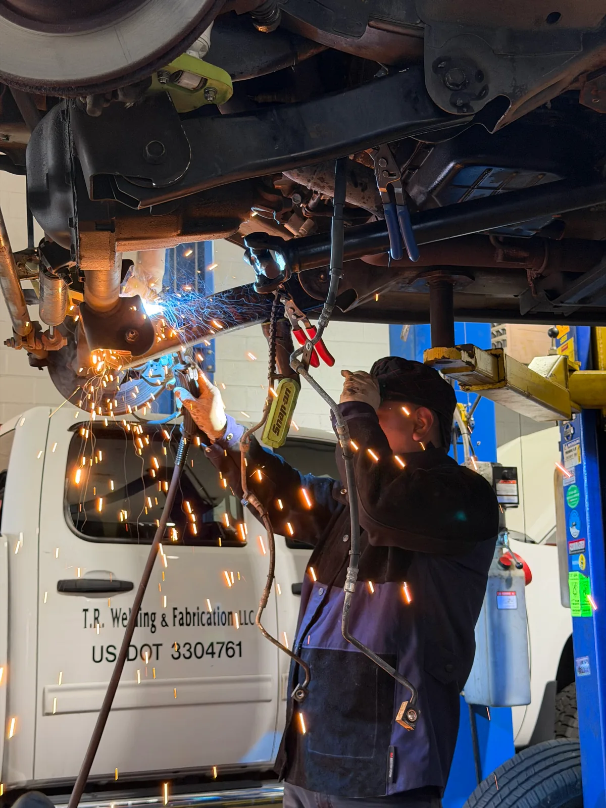 Welding repair on the undercarriage of a truck with sparks flying at the Wappingers Falls shop